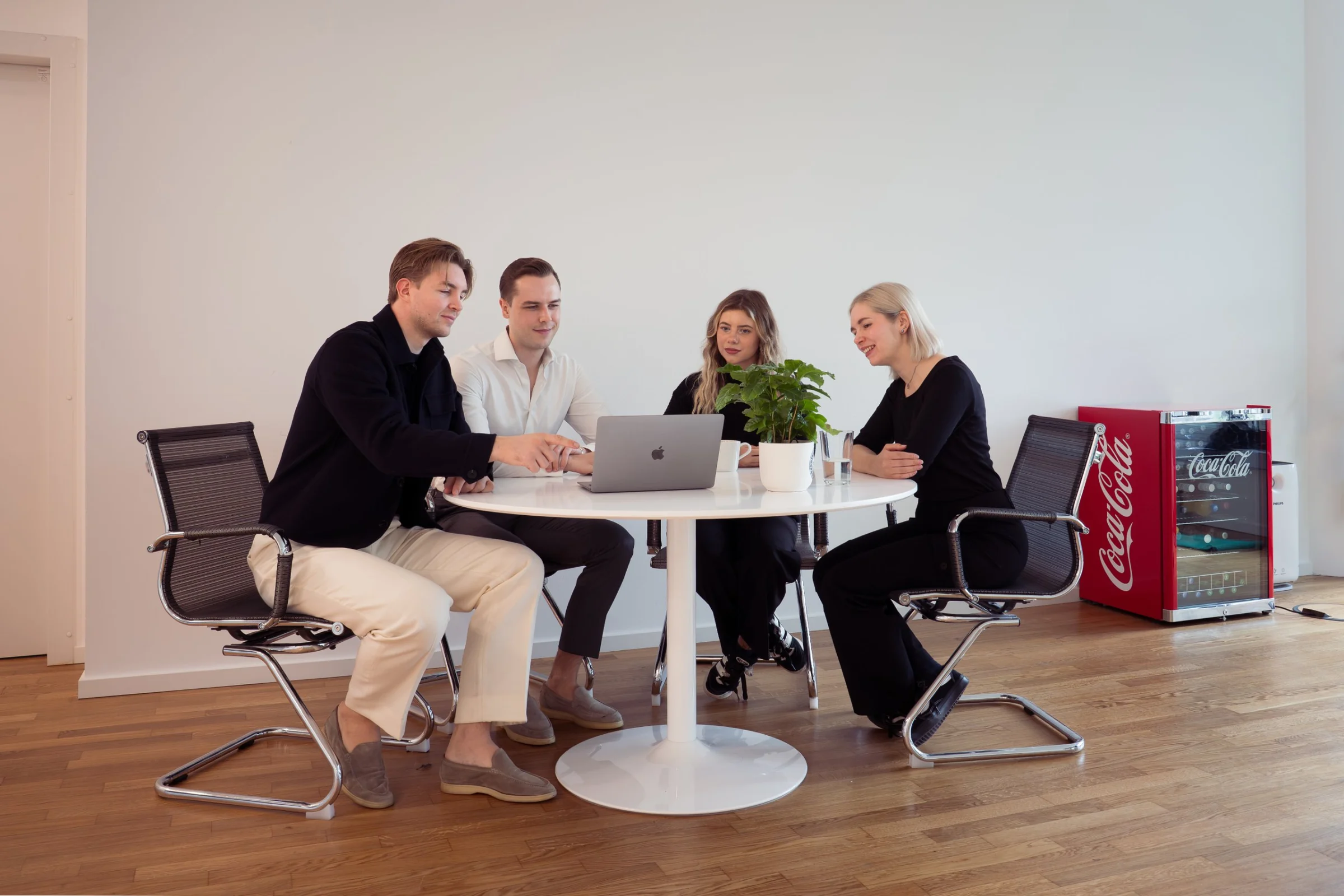 Henning, Jonas, Laura und Julia im Gespräch am Besprechungstisch im Office